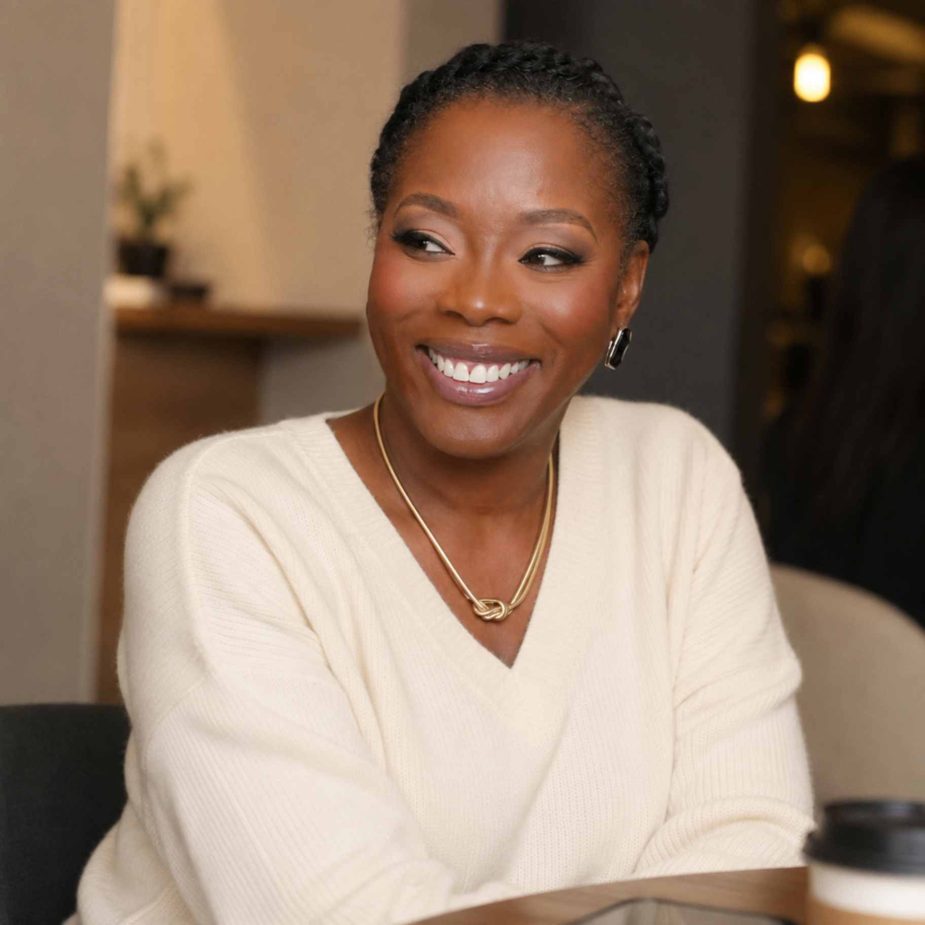 Yemisi, founder of True Wealth, smiling in a cream blazer